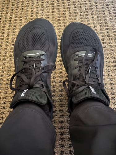 A top-down view of a customer wearing black MUUV Flow pickleball shoes, showing the wide toe box.