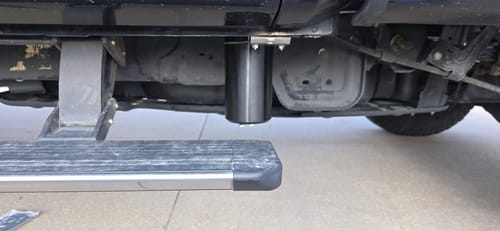 Customer's black SPE Motorsport CCV Catch Can installed vertically under the side of a truck, next to the running board.