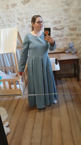 Cliente portant la longue robe Louisa en jean bleu, se prenant en photo dans un miroir.