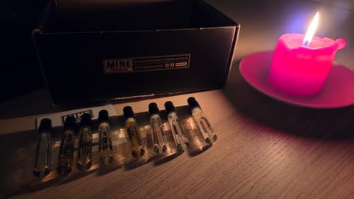 Foto di un cliente del set di campioni orientali e legnosi, con i flaconi disposti su un tavolo a lume di candela.