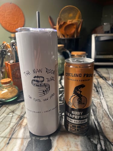 Customer's Ruby Grapefruit THC Seltzer can on a kitchen counter next to a white tumbler.