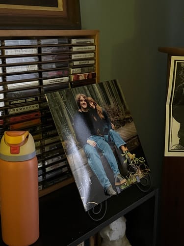 Customer's custom vinyl record cover with a personalized photo of a couple displayed on a stand.