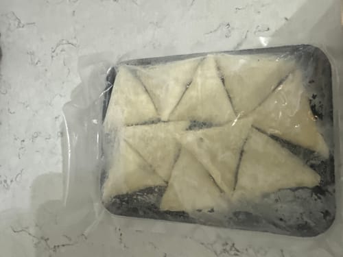 Customer's frozen Halal Meat Samosas, neatly vacuum-sealed in their black tray.