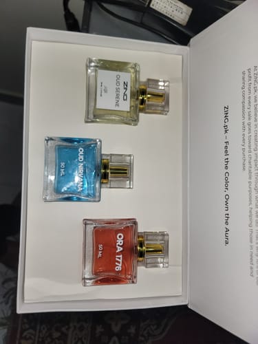 Customer's Signature Perfumes Bundle of 3 shown in an open white box. The bottles have red, blue, and yellow liquids.