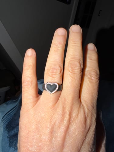 Customer's hand wearing the black silicone ring with a heart-shaped, stone-lined frame.