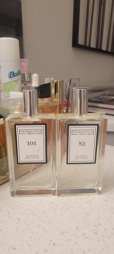 Customer's glass bottle of perfume #101, Inspired by Velvet Rose and Oud, shown next to perfume #82 on a counter.