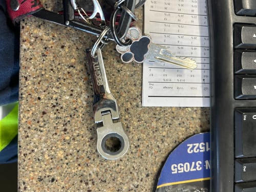 Customer's 10mm Wrench Keychain attached to a keyring on a speckled countertop.