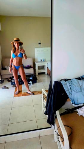 Customer's mirror selfie in a hotel room wearing the matching bright blue bikini.