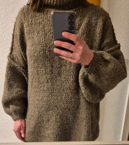 Rezensentin in einer Nahaufnahme, die den braunen Oversize Pullover 'CasualCozy' trägt.