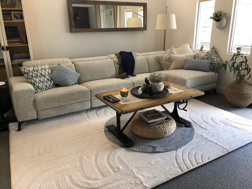 Customer's cream Mellow Mat with a carved pattern, shown in a living room under a coffee table.