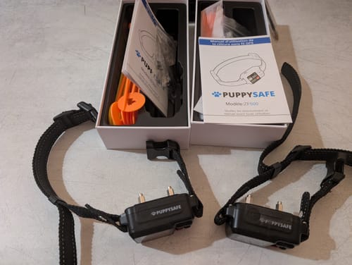 Deux colliers anti-fugue GPS d'un client, déballés avec leurs boîtes et manuels d'utilisation.