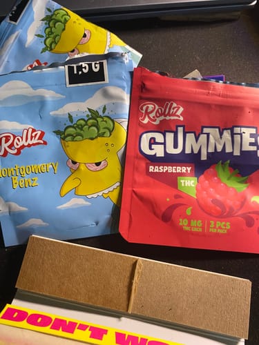 Customer's red pouch of ROLLZ THC gummies shown with other purchased products on a table.