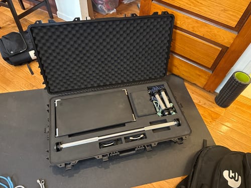 Customer's black CyberCase is open on the floor, showing gym equipment organized in the custom foam.