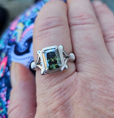 Customer's hand showing a Doveggs ring with a dark green rectangular stone in a vintage-style setting.