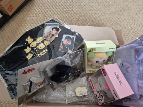 Reviewer shows the contents of their Ateez-themed K-POP RANDOM BOX, including plushies, photocards, and a tote bag.