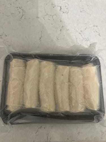 Customer's package of six frozen Halal Chicken Egg Rolls, vacuum-sealed in a black tray.