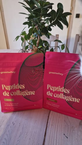 Photo d'un client montrant deux sachets roses de Peptides de Collagène posés sur une table.