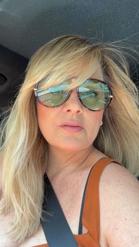 Cliente usando os Óculos Tropea com armação tartaruga e lentes verdes dentro de um carro.