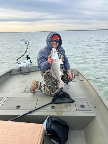 Customer on a boat holding a large redfish caught using the Sufix 832 Braid.
