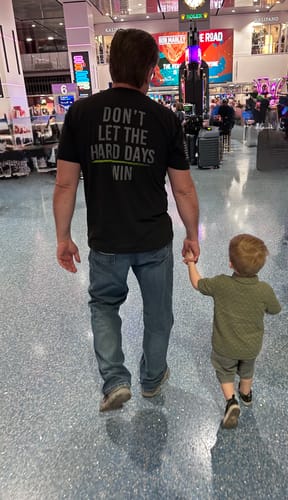Customer from behind, wearing the 'Keep Moving Forward' shirt with its 'Don't Let The Hard Days Win' message.