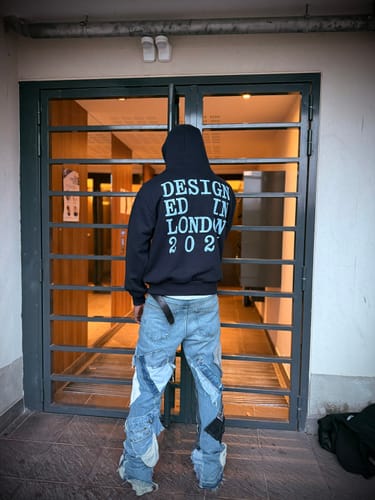 Reviewer from behind, wearing the black designed in london hoodie to show the large back graphic.