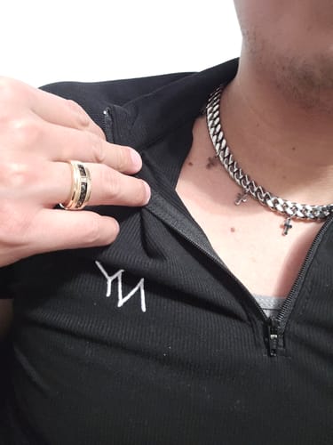 Close-up of a reviewer wearing the silver Crossed Cuban Necklace with a black quarter-zip shirt.
