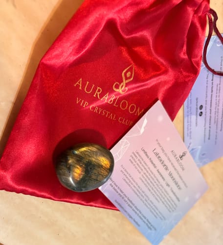 Customer's iridescent monthly crystal, shown with the red VIP Crystal Club pouch and an information card.