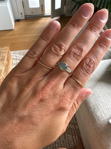 Customer's hand wearing the delicate, gold Twin Stacking Ring Set on their ring and pinky fingers.