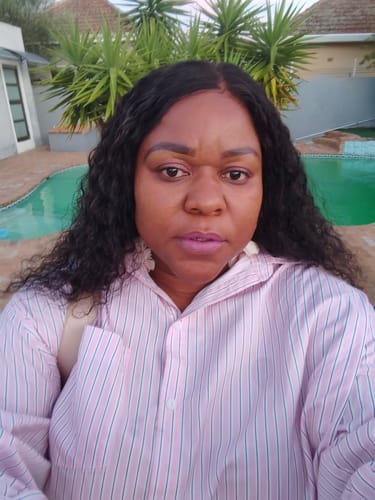 Reviewer wearing the long, voluminous Peruvian Water Wave Lace Wig outdoors.