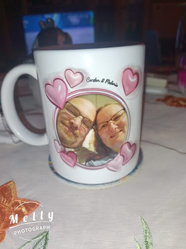 Rezensentenfoto einer personalisierten Tasse mit einem Foto eines Paares und rosa Herzen auf einem Tisch.
