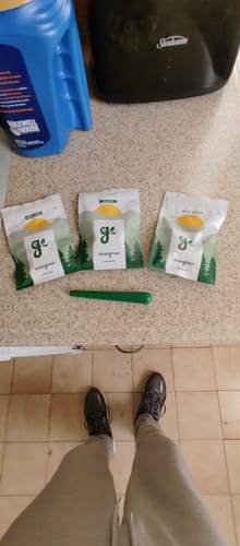 Customer displays their order of three sample pouches, including Royal Cherry, with a green pipe on a counter.