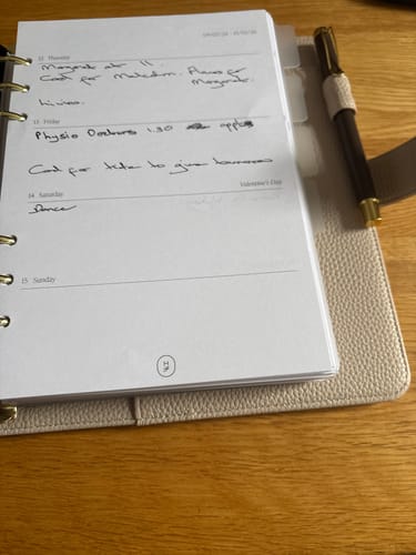 Customer's open Agenda - 2026 Weekly Pack with handwritten entries shown in a binder on a desk.