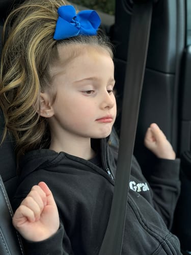 Customer wearing the Stranded Clip-in Ponytail, showing its wavy texture and blonde color.