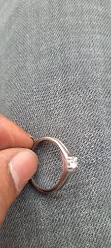 Customer holding the silver-colored Classy Zirconia Ring against a grey textured background.