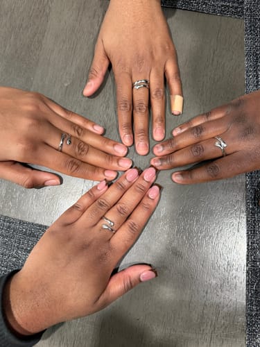 Customer's photo of four hands together, each wearing a matching silver wrap ring on the middle finger.