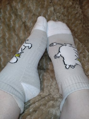 Kund som visar de grå Mumin Ankelstödstrumporna med Mumintrollet på.