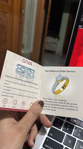 Reviewer holding the informational GIVA booklet that came with the kids bracelet.