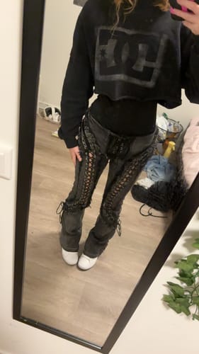 Customer takes a mirror photo wearing the black denim LOW RISERS with full-leg lace-up details.