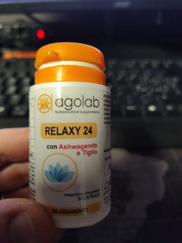 Un recensore tiene in mano la boccetta bianca e arancione di Relaxy 24, mostrando l'etichetta del prodotto.