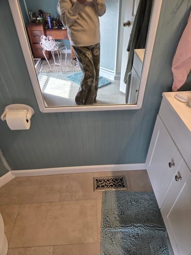 Customer showing the fit of their green floral pants in a mirror selfie.