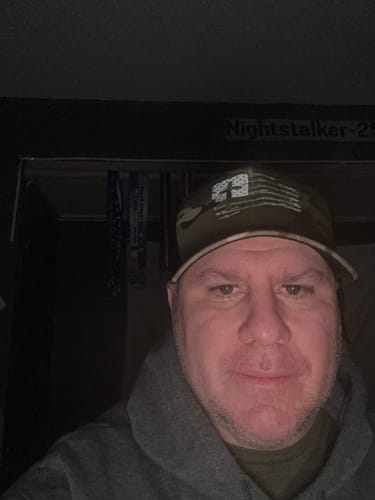 Customer wearing the Tattered Flag Cross Camo Hat in a close-up view