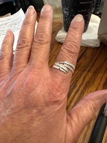 Customer wearing the comfortable Feather From An Angel Ring wrapped around their finger.