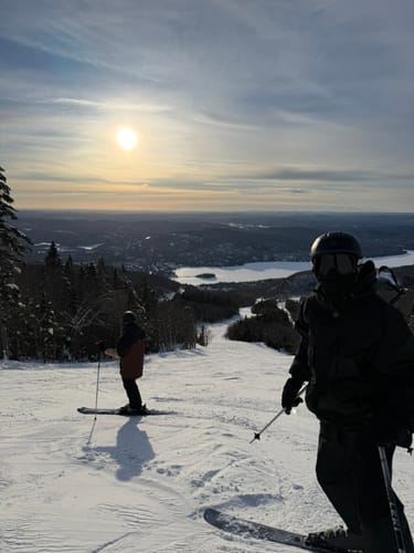 Customer wearing the Insulated Snow Jacket on a snowy ski slope overlooking a valley.