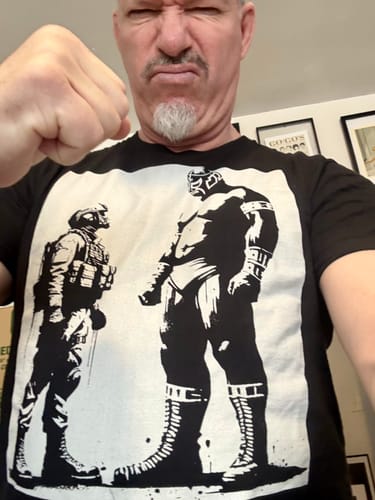 Reviewer wearing the black Sin Lucha No Hay Victoria t-shirt while making a fist.