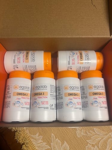 Recensore mostra sei flaconi dell'integratore Omega 3 Triaction di Agolab in una scatola.