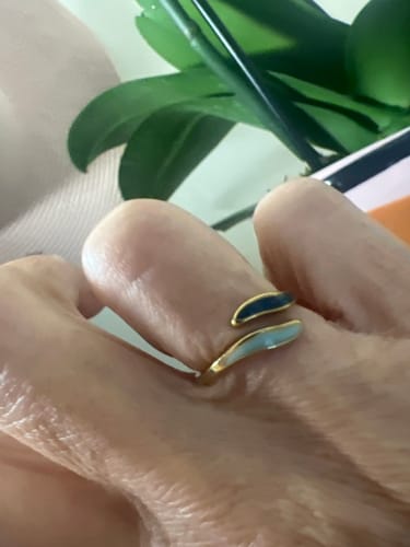 Reviewer's hand showing the adjustable Aquamarine Wrap Ring with its oblong, two-toned blue design.