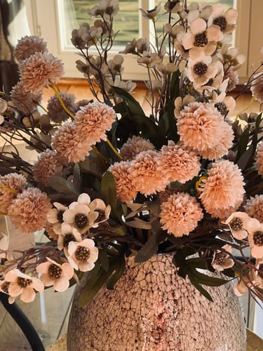 Recensent toont een close-up van het mooie Wax Arrangement met crème en roze bloemen in een vaas.