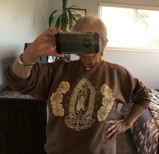 Reviewer posing in a mirror wearing their brown Chocolate Lupita Sweatshirt.
