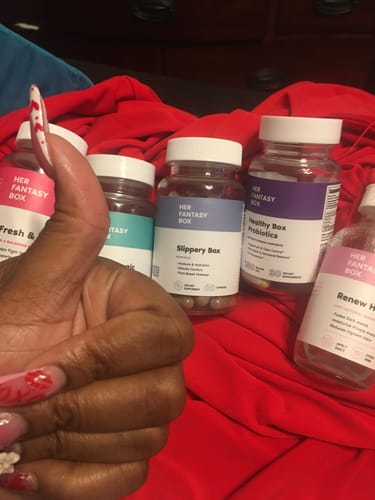 Customer gives a thumbs-up, showing their bottle of Slippery Box capsules among other products.