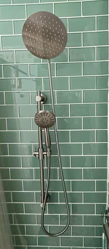 Customer's metal 3-Spray Hand Held Shower Head Set installed on its slide bar in a modern shower with green tiles.